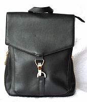 Black leatherette backpack with front flap, one compartment, interior zipper pocket visible, small blemish on flap