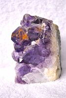 Front view showing purple amethyst crystal clusters with orange inclusions and sparkling crystal facets.