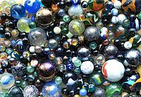 Close-up image showing a dense grouping of various marbles with many colors and designs.