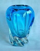 Front and side view of the blue blown glass vase showing swirling free-form design with smooth polished base.