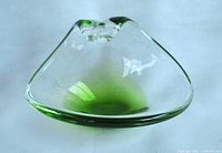 Top view of emerald green to clear glass trinket dish showing smooth transition of colors and curled handle.