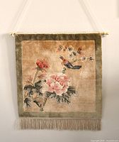 Full frontal view of the wall hanging rug showing detailed floral and bird design with fringes and hanging rod.