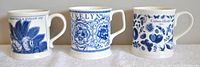 Front view of three blue on cream coloured Crabtree & Evelyn commemorative mugs with detailed floral and pattern designs, showing years 2009, 2010, and 2011 respectively.