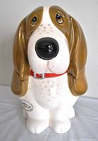 Front view of a ceramic cookie jar shaped as a basset hound dog with a large black nose and brown and white face, showing signature style of The Pioneer Woman.