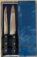 Two knives in original box with blue marble-patterned lid and gold inscription 'Our Special Thanks from your Rainbow Distributor', made in Japan.