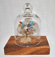 Full view of gemstone tree of life under glass dome on wooden base showing multicolored gemstone chips and clean clear dome.