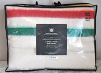 Packaged throw in clear bag with black binding showing front label with brand and product name