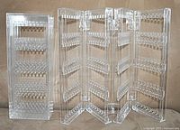 Two clear plastic folding earring display holders showing multiple rows of earring slots on each panel.