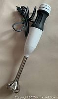 Photo of the Kitchen Aid hand mixer showing the body, blending shaft, and power cord.