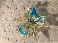 Top view of the large Murano glass home decor showing four recessed sections with blue and yellow highlights in clear glass.