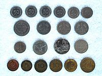 Top view of 20 foreign coins arranged in rows on white background showing denominations and years.