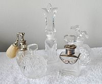 All 6 vanity scent bottles arranged on white towel showing different shapes and metal/fabric details