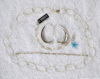 Full lot of 4 sterling silver jewelry pieces on white cloth background: large link chain necklace, hammered open hoop earrings, hammered link bracelet with blue star charm, and a long thin rope chain necklace.