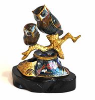 Front side view of the cloisonné owl incense burner showing two owls perched on a gold branch over a detailed enamel base on a black wooden stand.