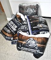 Five bags of Pit Boss BBQ hardwood pellets arranged on floor, showing packaging and labels stating 100% natural hickory blend.