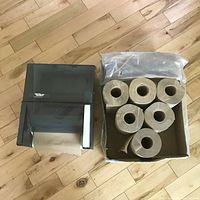 Top view showing paper towel dispenser alongside six rolls of paper towels in a box.