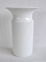 Front view showing the full shape of the white porcelain vase with a flared lip and cylindrical body.