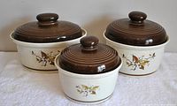 Set of three covered bowls with lids showing front cherry motif and brown lids