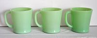 Front view showing all three Jadeite green Fire King coffee mugs lined up side by side.