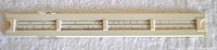 Plastic case for the slide rule in light beige with compartments for components.
