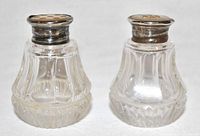 Pair of cut crystal salt and pepper shakers with sterling silver tops shown.