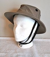 Side view of khaki Tilley hat on mannequin showing wide brim and chin strap.
