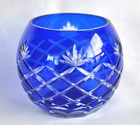 Front angled view of the cobalt blue round crystal vase showing intricate cut diamond and leaf patterns.