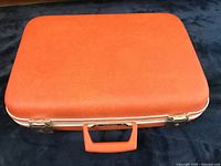 Top view of closed vintage suitcase showing brown hard cover and sturdy handle.