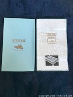 Photo of unopened Heritage branded box with damask tablecloth set inside showing original packaging.