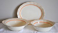 Three piece serving set including oval plate and two round bowls on white surface