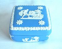 Side view of blue Wedgwood jasperware trinket box showing white cherub relief and corner details