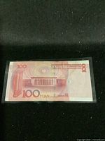Back side of 100 Yuan banknote showing Great Hall of the People and denomination.