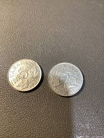 Two 1932 Canadian 5-cent nickel coins showing front face with denomination and maple leaf design on dark background.