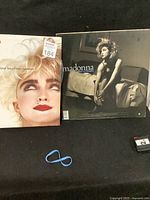 Photo showing both vinyl record albums: 'Like a Virgin' with Madonna sitting on a bed, and 'Who's That Girl' soundtrack with Madonna's close-up portrait.