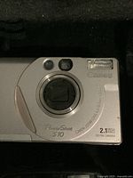 Close-up photo of Canon PowerShot S10 silver camera showing lens, flash and branding details