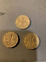 Photo showing three Canadian 1943 5 cent coins with torch and maple leaf design.