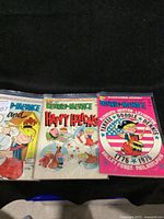 Three Dennis the Menace comic books laid out side by side showing colorful covers