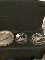 Three tin Egyptian wall plaques arranged side by side on a black background.