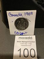 Canadian 50 cent coin from 1969 displayed in a white holder showing the reverse side with the Canadian coat of arms and labeled 'Canada 1969 50 cent'.
