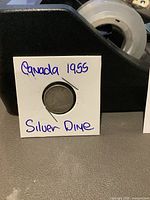 Photo of the 1955 Canadian silver 10 cent coin in protective 2x2 holder labeled with handwritten text.