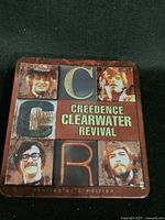 Front of the metal tin featuring band member photos and 'CCR' lettering