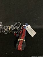 Image showing multiple incomplete dog collars including a red leather one with metal studs and blue buckle and black ones with metal spikes.