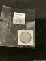 Front side of the commemorative coin showing an astronaut and lunar lander design