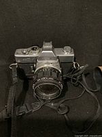 Front view of Minolta SRT 101 camera showing lens, top controls, and strap