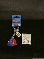 Top-down photo of new LEGO Superman key chain with packaging label, minifigure, and LEGO logo charm on key ring.