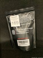 Back of black resealable bag with text explaining the puzzle's clear piece design and challenge