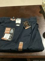Folded navy dress pants with Haggar brand tags showing size 37 x 32 and premium label.