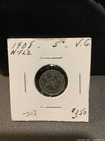 Photo of 1908 Newfoundland 5 cent silver coin mounted on white cardboard holder, showing coin face and handwritten label with condition and price details.