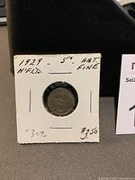 Photo of a 1929 Newfoundland 5 cent silver coin mounted in a white cardboard holder with handwritten notes.