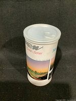 Front view of the cylindrical canister showing scenic city landscape artwork and part of the product labeling.